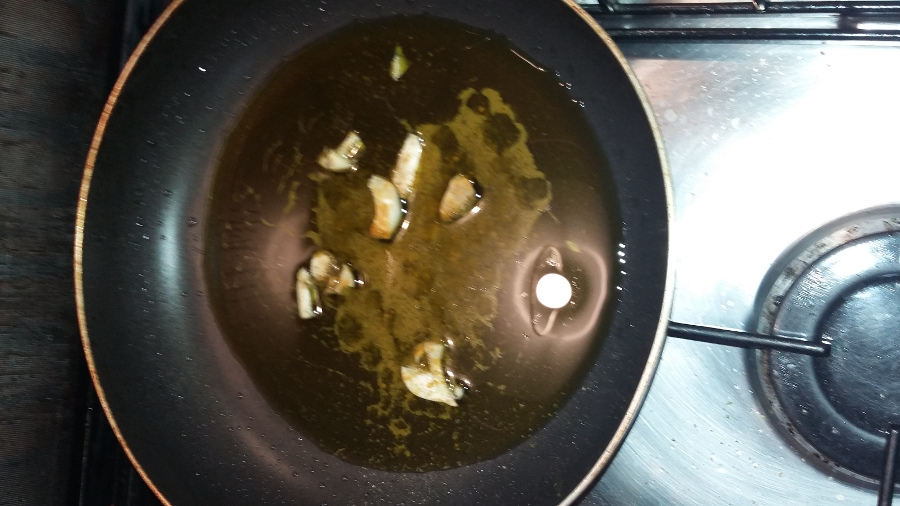 aglio schiacciato in padella cosparsa d'olio